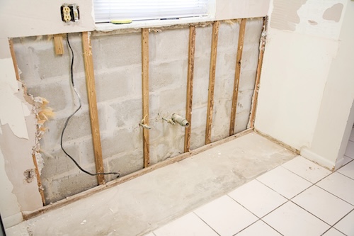 Interior of kitchen with drywall torn out because of water damage and the resulting mold.