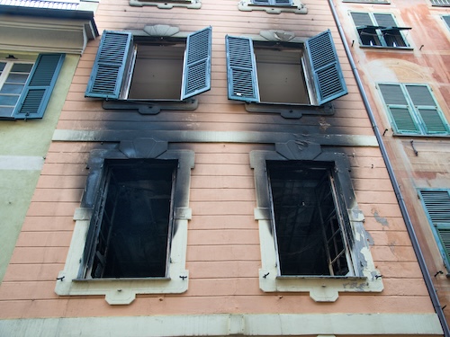 front of a home with burned out windows needing fire damage cleanup